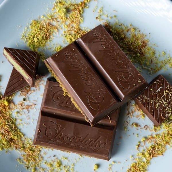 Ranoush chocolate bars and triangular pieces with pistachio filling, sprinkled with nuts and shredded phyllo.